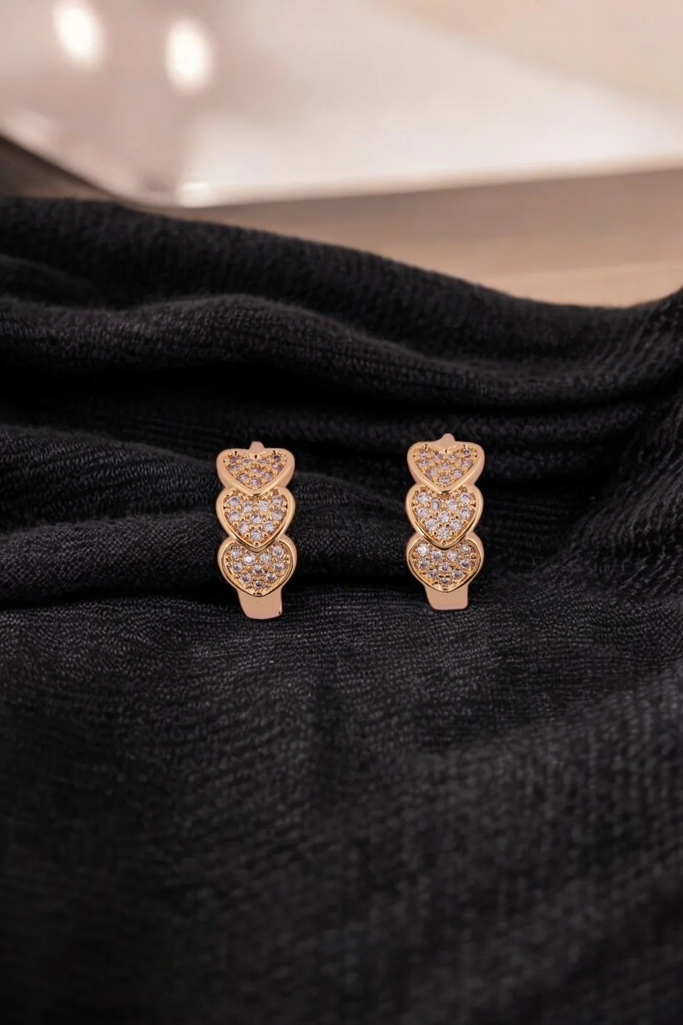 Elegant Gold-Tone Triple Heart Stud Earrings with Crystal Detailing - Amulya Gems